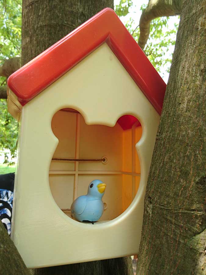 A 3D-printed toy birdhouse with a blue bird