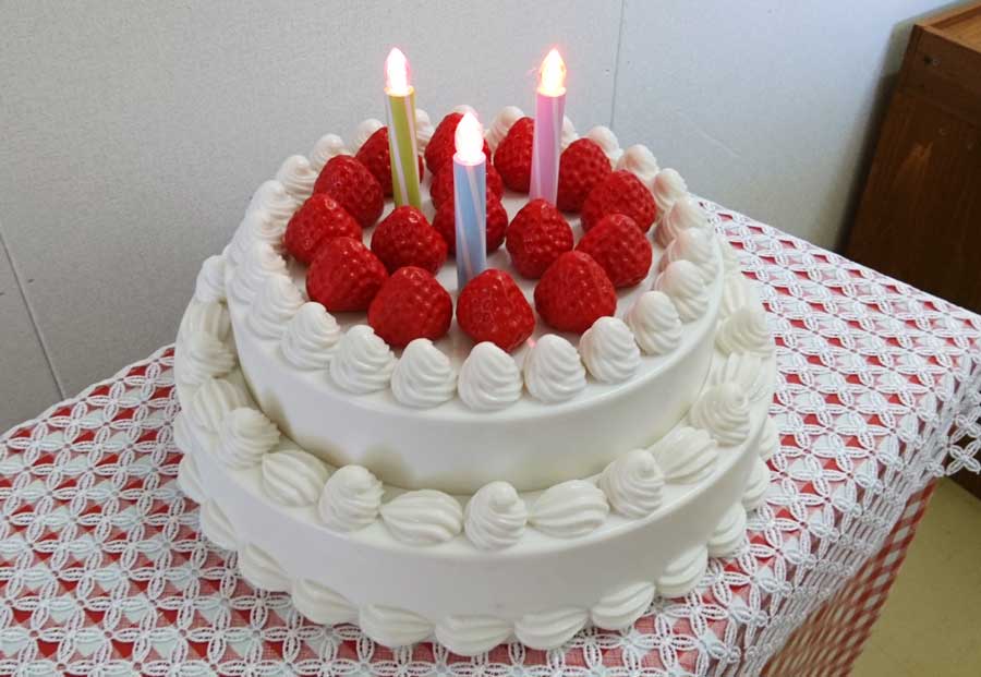 A 3D-printed white birthday cake with strawberries