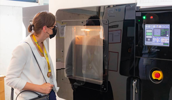 Belgian Federal Mobility Policy Chief Emmanuelle Vandamme looking at an FDM printer during a visit at Materialise
