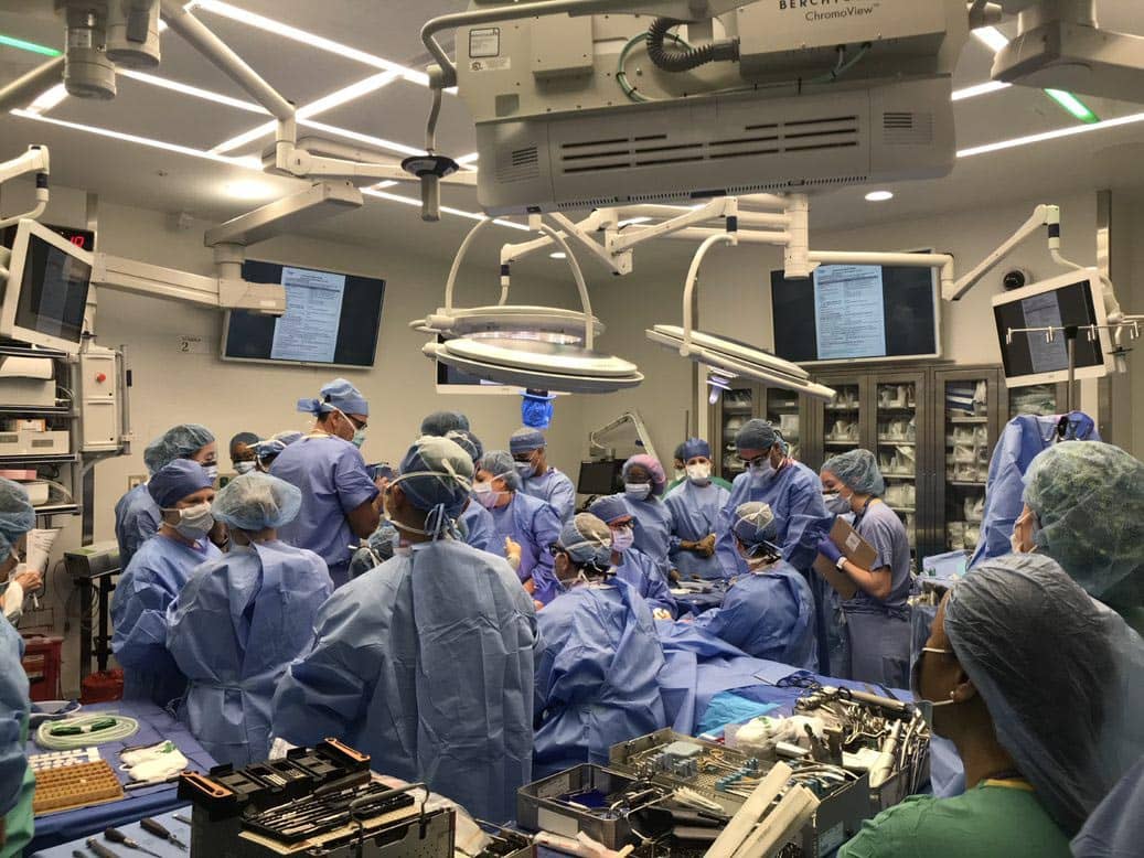 A team of surgeons and clinicians in an operating room rehearing the surgery procedure