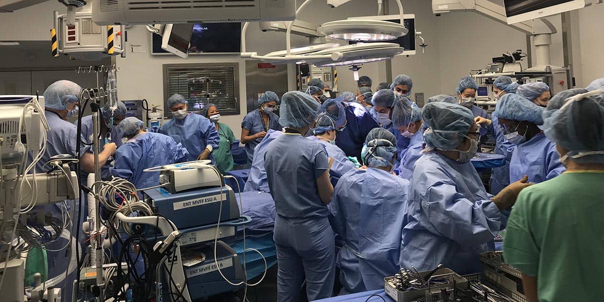 Surgeons and nurses in the operating room during a double hand and face transplant